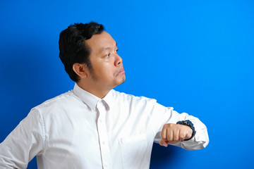 Asian businessman wearing white shirt check time on his wrist watch