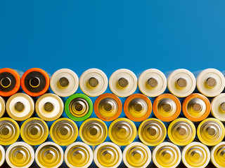 A lot of color AA batteries on a blue background.