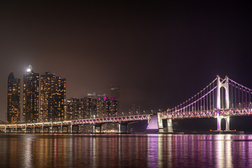 Fototapeta na wymiar Gwangan Bridge, an international landmark, and the night view of skyscraper in Busan, South Korea