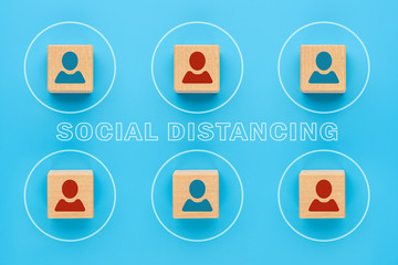 Social distance, people use social distance to protect themselves from the COVID-19 coronavirus. Wooden cubes with the image of a person separated from each other, the concept of infection prevention.