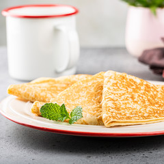 Delicious Tasty Homemade crepes or pancakes with honey, honey and mint on white plate. Healthy breakfast concept, gluten free. Copy space.