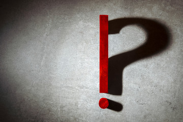exclamation point lit in spotlight changes into a question mark from shadow. Question mark,...