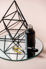 Fototapeta na wymiar Black glass bottle with pipette and anti aging serum oil