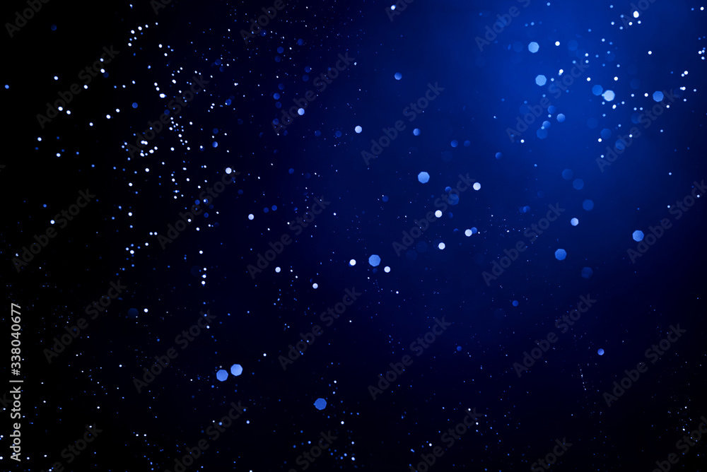 Wall mural abstract dark background with glowing blue particles.