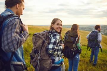 Group of friends trekking with backpacks walking in the forest .