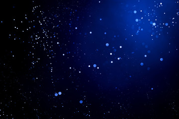 Abstract dark background with glowing blue particles.