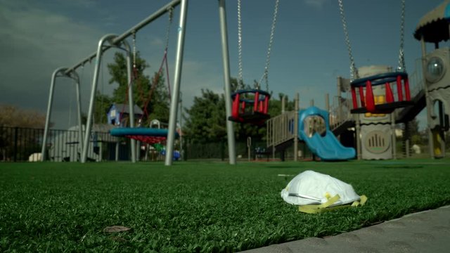 Abandoned respiratory, medical face mask human on empty children playground. City quarantine. Coronavirus, &nbsp;covid 19 epidemic. Worldwide &nbsp;emergency situation. Virus protection. Spring sunny day.