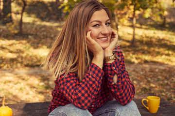 Portrait of beautiful woman enjoying and posing in autumn day.