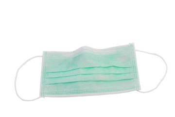 Protective face mask on wood table. Typical 3-ply surgical mask to cover the mouth and nose. Procedure mask from bacteria. Protection concept. Surgical mask with rubber ear straps. covid 19