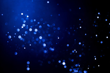 Abstract dark background with glowing blue particles.