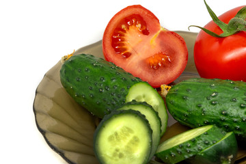 green fresh sliced cucumber and tomato on glass plate