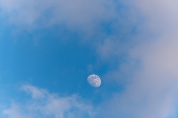 Three Quarter Moon in a Blue Sky with Clouds