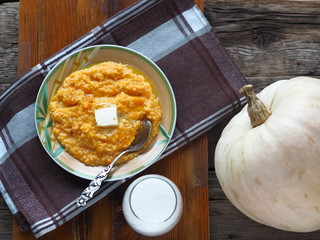 Millet porridge with pumpkin on wooden background. Healthy eating concept.
