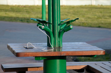 The mobile phone is on the table and is charged from solar panels.