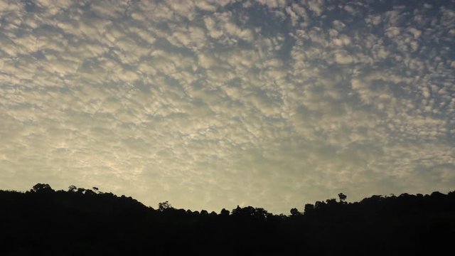 Time lapse video  of clouds in morning sky over forest and hills 