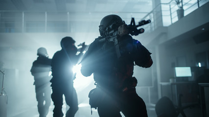 Masked Squad of Armed SWAT Police Officers Move in a Hall of a Dark Seized Office Building with...