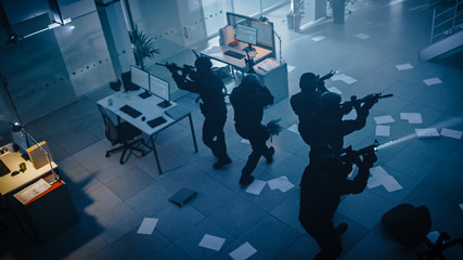Masked Squad of Armed SWAT Police Officers Storm a Dark Seized Office Building with Desks and...
