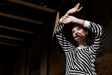 Beauty Fashion Model Girl with Brown Hair on a background of an old, abandoned building, wearing stylish clothes.