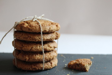 oatmeal homemade cookies are stacked on top of each other on a gray stone table on a white background side view
