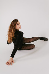 Stylish beautiful dancer wearing black leotard and black tights with polka dot on the white backgroud