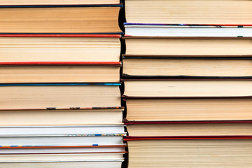 Book background, stacks of books are tightly standing side by side. The concept of library and reading.