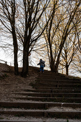 Obraz premium Child climbing on a stair on an autumn day with trees in the background