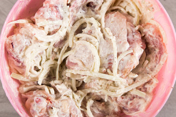 Chicken thighs with onions and mayonnaise, a simple recipe for homemade attraction, preparation for baking.