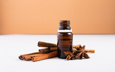 natural cosmetics concept, composition of glass bottles with oil and cinnamon sticks on a white background