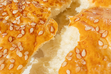A crust of freshly baked bread with sesame seeds. The concept of bakery products. Abstract food...