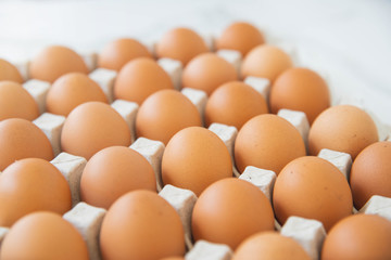Close-up view of raw chicken eggs in egg box on wooden background. Raw chicken eggs in egg box organic food for good health high protein .