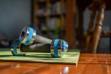 Dumbbells and yoga mat on home floor