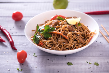 Japanese dish buckwheat noodles soba with chicken and vegetables carrots, bell peppers, mushrooms, green onions