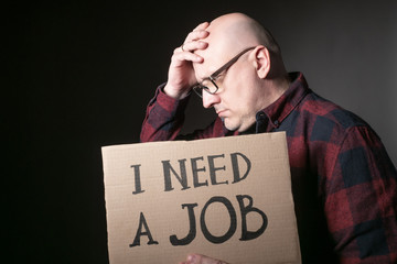 Unemployed in search of work. Man shows the sign I need a job. Concept - human was fired due to the...
