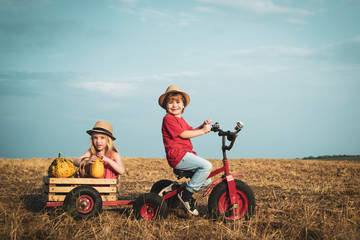 Little friends on countryside. Little boy with little girl - kids couple in love. Little children - funny couple posing smiling and having fun on bike