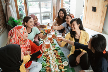 Obraz premium tea time with friend during lunch. muslim asian woman with friends together. toast their glass