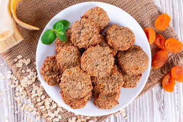 Homemade oatmeal cookies with banana, oats on a wooden background. Healthy breakfast concept.