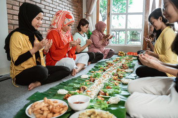 asian muslim woman pray before having their lunch with friend