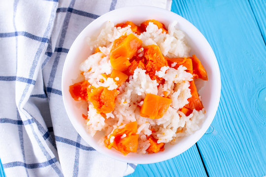 Pumpkin porridge with rice on a blue wooden background. Healthly food. Baby food