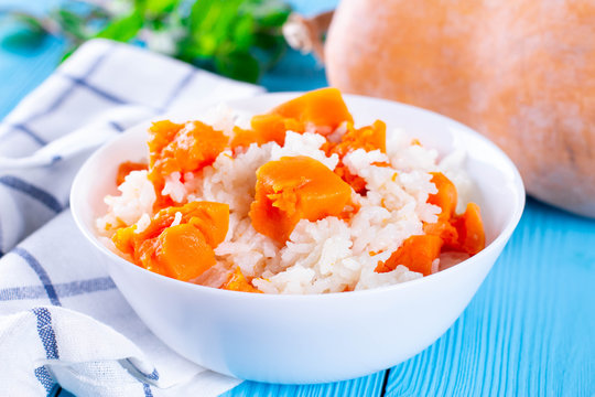 Pumpkin porridge with rice on a blue wooden background. Healthly food. Baby food - Powered by Adobe