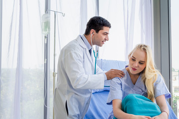 Obraz premium Caucasian female patient in bed and doctor use stethoscope analyze symptom sick at hospital