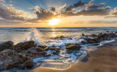 Sunset over the rocky shore of the Gulf of Mexico at Caspersen Beach in Venice Florida