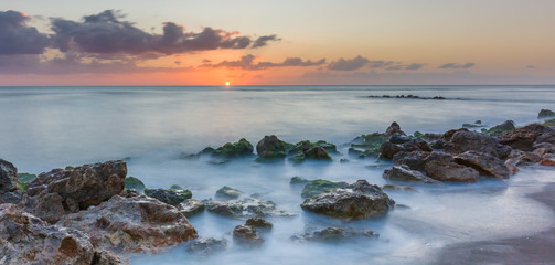 Naklejka premium Sunset over the rocky shore of the Gulf of Mexico at Caspersen Beach in Venice Florida