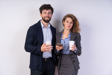 Business people drinking coffee together and at the same time communicate, keep the smartphone smile looking right