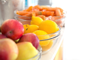 Fresh lemons. Yellow lemons with apple and carrots in the background