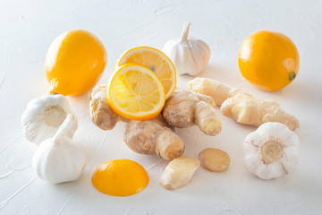 Ginger, garlic and lemon - a means to protect against viral infection and colds on a light wooden table.