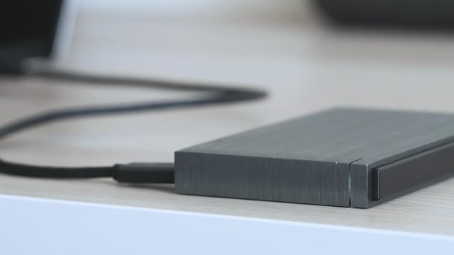 External Hard Drive On a Table, Led Light Flickering - Solid Aluminium Casing HDD, Minimalist Design Composition - Macro Closeup