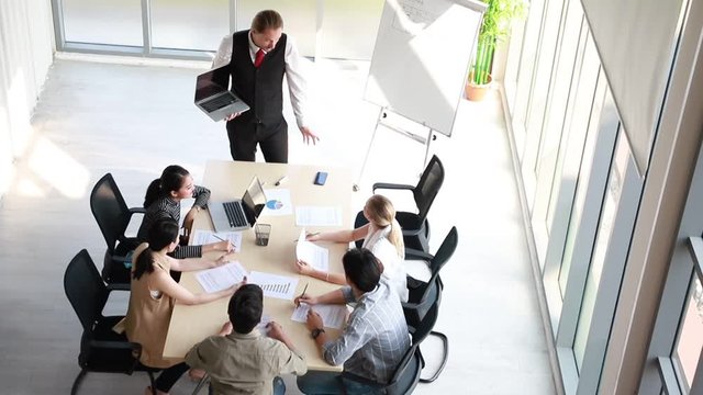 Top view of businessman coach speaker holding laptop computer with flipchart, Speaker presenter consulting training persuading employees client group, Business meeting, seminar, presentation concept.