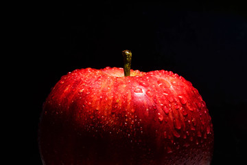 natural organic apple with natural water drip show fresh skin on black background