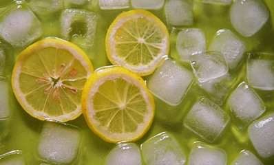 Lemons on the ice on the green background.