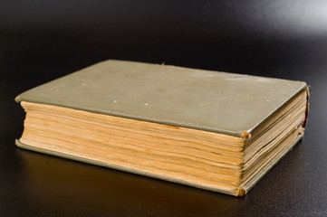 An old book with yellowed pages and a battered cover. Background for knowledge and history.